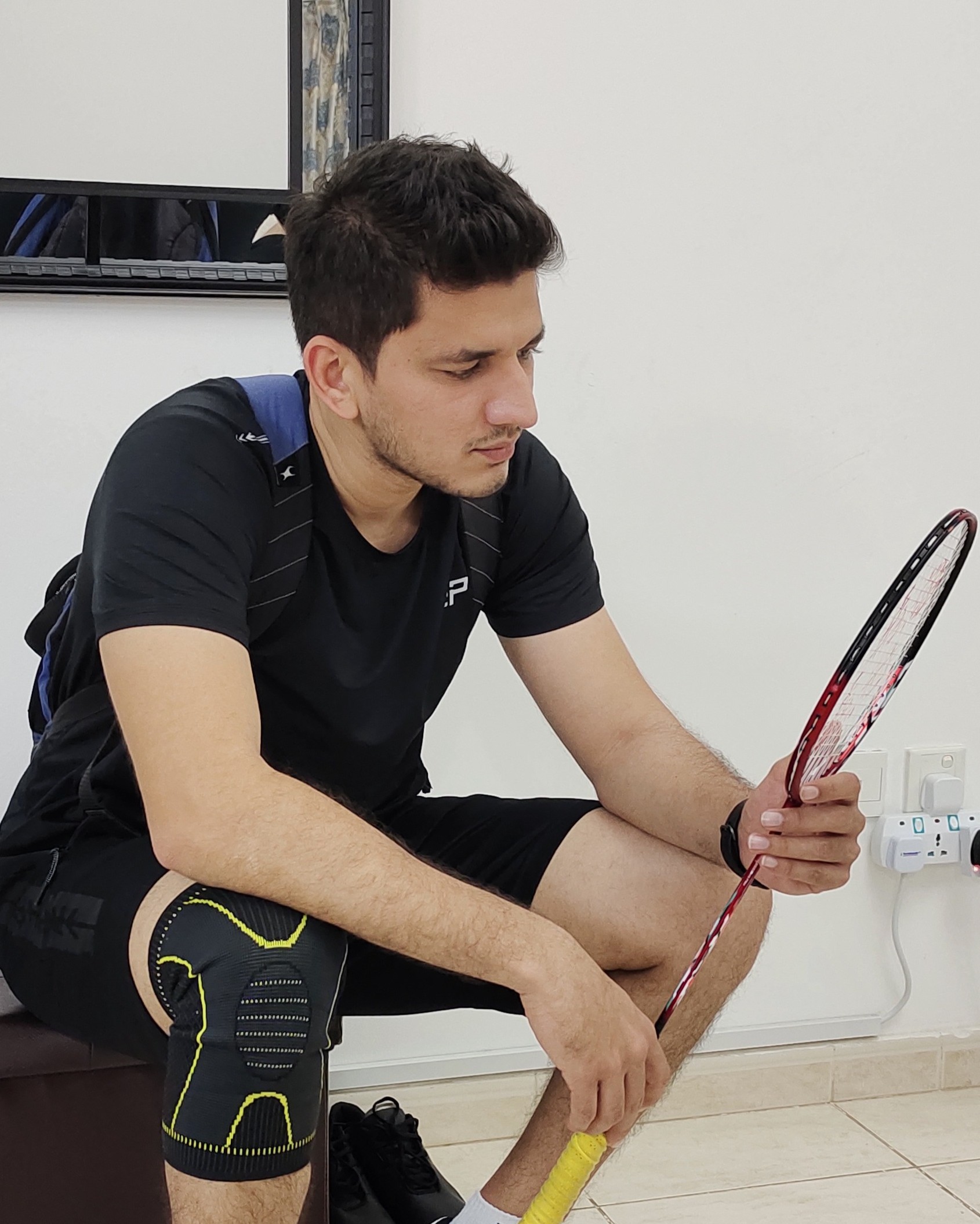 Me re-gripping a badminton racket before a match